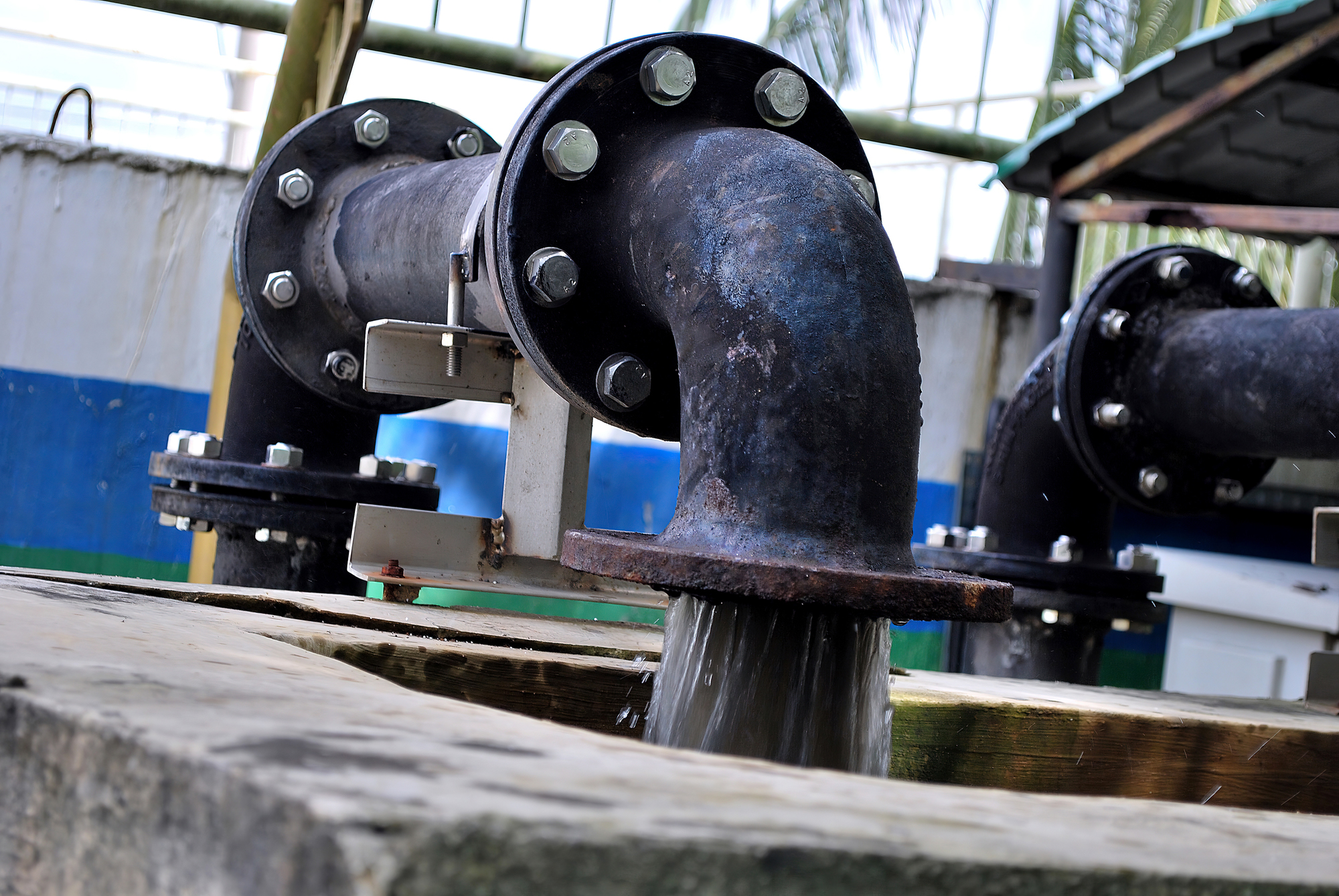 Rusty steel desludging water treatment pipe releasing the sludge